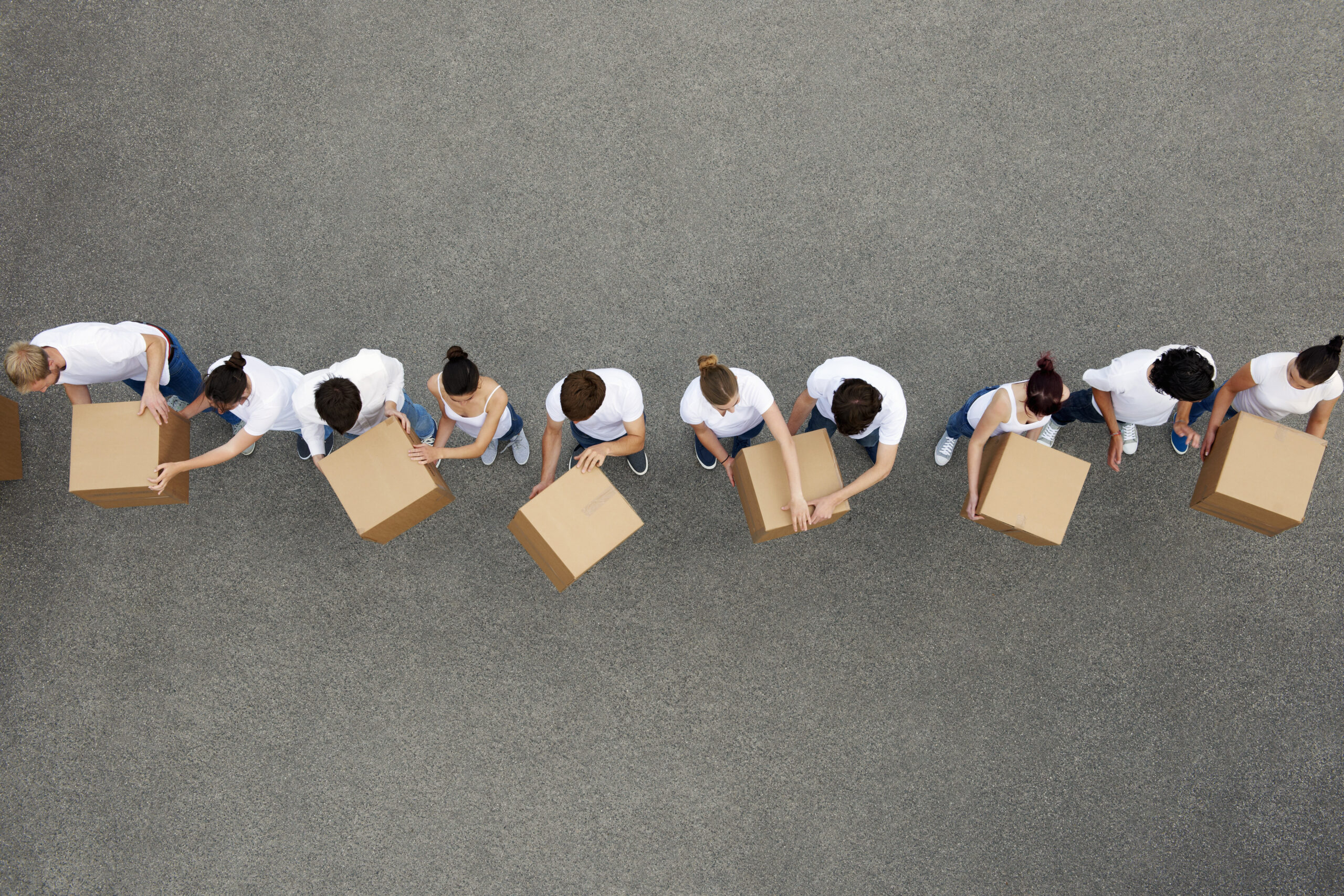 People passing cardboard boxes
